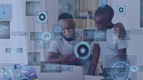 Animation-of-data-processing-over-african-american-father-and-son-using-laptop-discussing-at-home