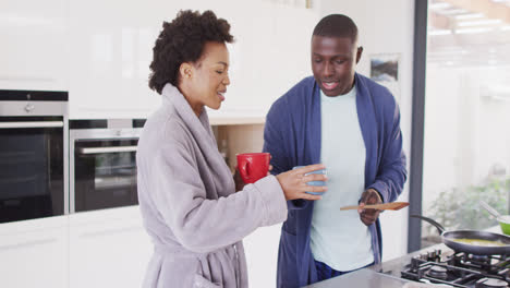 Video-Eines-Glücklichen-Afroamerikanischen-Paares,-Das-Gemeinsam-In-Der-Küche-Frühstück-Und-Kaffee-Zubereitet