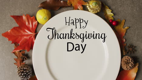 Animation-of-happy-thanksgiving-day-text-and-plate-and-autumn-leaves-over-grey-background