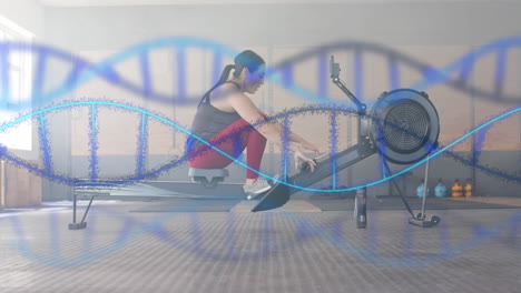 Animation-of-dna-strands-over-caucasian-woman-training-on-rowing-machine-at-gym