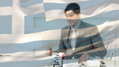 Waving-greece-flag-against-caucasian-young-businessman-celebrating-at-office