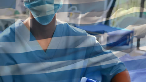 Animation-of-greece-flag-against-portrait-of-biracial-female-surgeon-in-surgical-mask-at-hospital