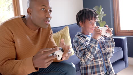 Afroamerikanischer-Vater-Und-Sohn-Spielen-Videospiele-Zu-Hause,-Zeitlupe