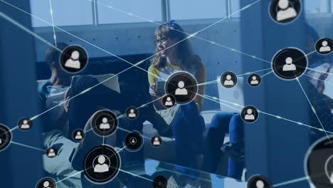 Animation-of-network-of-connections-with-icons-over-diverse-business-people-having-meeting-at-office