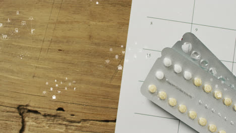 Animation-of-multiple-icons-over-tablets-on-prescription-paper-on-wooden-table