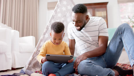Glücklicher-Afroamerikanischer-Vater-Und-Sohn,-Die-Ein-Tablet-Benutzen-Und-Zu-Hause-High-Five-Machen,-Zeitlupe