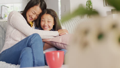 Video-De-Feliz-Madre-E-Hija-Asiáticas-Sentadas-En-El-Sofá-Y-Divirtiéndose