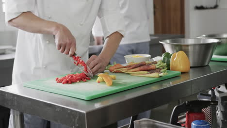 Caucasian-male-chef-cutting-vegetables-in-kitchen,-slow-motion