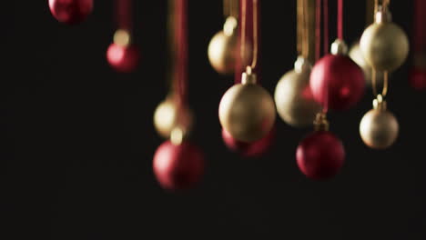 Video-of-gold-and-red-baubles-christmas-decorations-with-copy-space-on-black-background