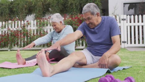 Feliz-Pareja-Diversa-Senior-Practicando-Yoga-En-El-Jardín