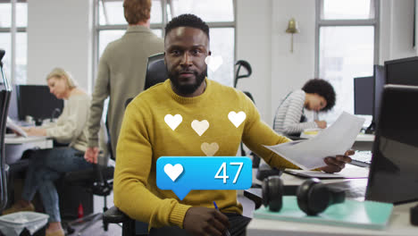 Animation-of-like-icon-with-increasing-numbers-over-african-american-man-smiling-at-office