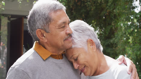 Happy-senior-diverse-couple-embracing-in-garden