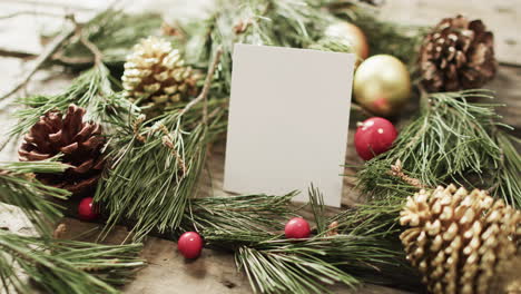 Video-of-christmas-decorations-and-white-card-with-copy-space-on-wooden-background