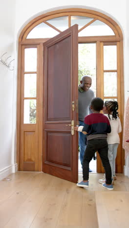Fröhliche-Afroamerikanische-Kinder-Begrüßen-Vater-An-Der-Haustür,-Zeitlupe