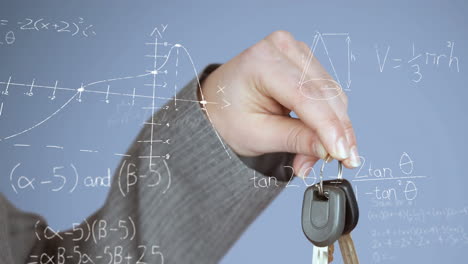 Animation-of-mathematical-equations-floating-against-close-up-of-a-hand-hoding-car-keys
