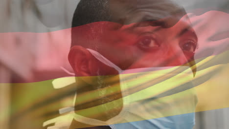 Animation-of-waving-germany-flag-against-close-up-of-african-american-man-in-face-mask-on-the-street