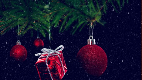 Animation-of-snow-falling-over-hanging-baubles-and-christmas-gifts-on-a-branch-on-black-background
