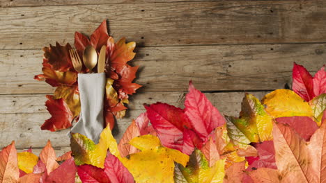 Animation-of-autumn-leaves-over-thanksgiving-dinner-place-setting-background
