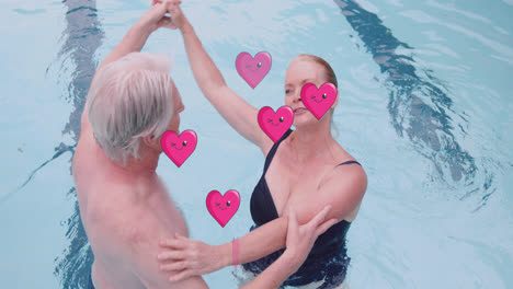 Animation-of-heart-icons-over-caucasian-senior-couple-dancing-in-pool