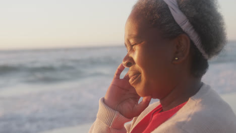 Happy-senior-african-american-woman-smiling-at-beach,-in-slow-motion