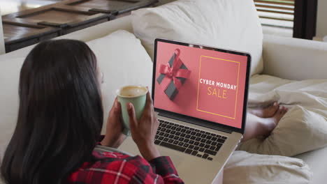 Biracial-woman-using-laptop-at-home-online-shopping-on-cyber-monday-sale-day,-slow-motion