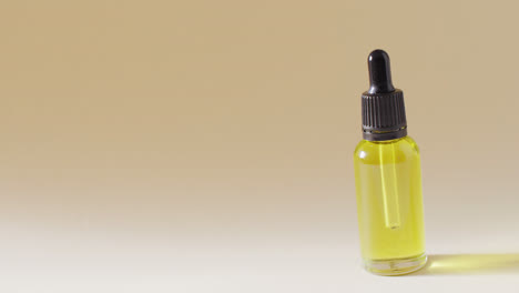 Close-up-of-dropper-serum-bottle-on-beige-background-with-copy-space