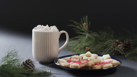 Video-of-christma-cookies,-mug-of-chocolate-and-copy-space-on-black-background
