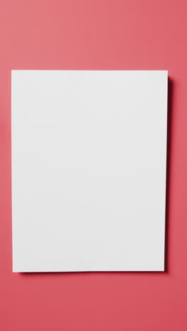 Vertical-video-of-white-card-with-copy-space-on-red-background