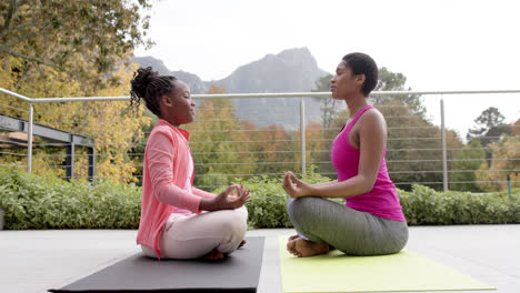Feliz-Hija-Afroamericana-Y-Madre-Practicando-Yoga-En-El-Jardín,-Cámara-Lenta