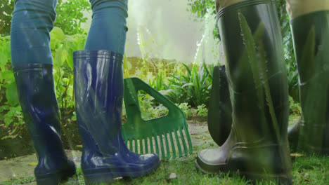 Animation-of-grass-over-legs-of-two-people-wearing-rubber-boots-working-in-garden