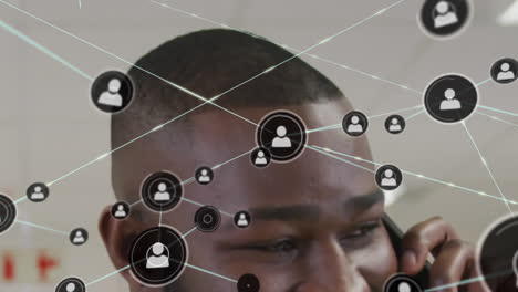 Animation-of-network-of-profile-icons-against-close-up-of-african-american-man-talking-on-smartphone