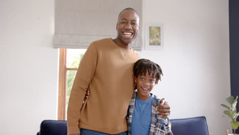 Portrait-of-happy-african-american-father-and-son-embracing-at-home,-slow-motion