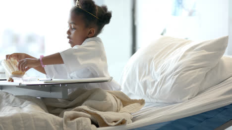 African-american-girl-eating-lunch-in-hospital-bed,-slow-motion