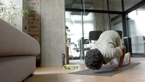 African-american-man-doing-yoga-and-stretching-at-home,-slow-motion