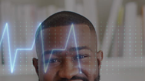 Animation-of-heart-rate-monitor-against-half-face-portrait-of-african-american-male-doctor-smiling