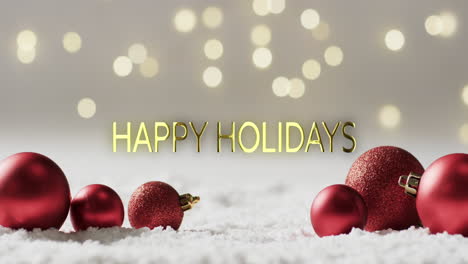 Frohe-Feiertage-Text-Mit-Glitzernden-Roten-Weihnachtskugeln-Auf-Schnee-Und-Bokeh-Lichter-Hintergrund
