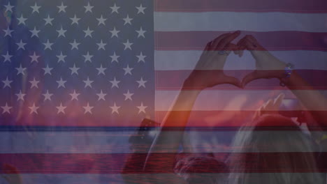 Animation-Der-Amerikanischen-Flagge-über-Den-Händen-Der-Menge-Beim-Konzert,-Die-Eine-Herzform-Bildet-Und-Winkt