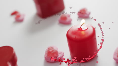 Animation-of-multiple-red-hearts-over-red-candles