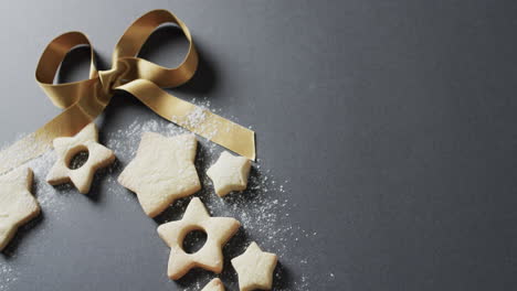 Video-of-christma-star-cookies-decorated-with-sugar-and-ribbon,-copy-space-on-black-background