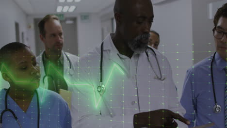 Animation-of-heart-rate-monitor-over-team-of-diverse-doctors,-health-workers-discussing-at-hospital