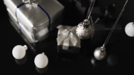 Video-Von-Silbernen-Kugeln,-Weihnachtsdekorationen-Und-Geschenken-Mit-Kopierraum-Auf-Schwarzem-Hintergrund