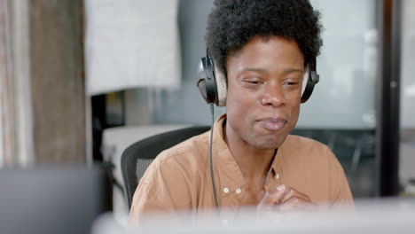 Happy-african-american-man-in-headphones-talking-during-live-podcast,-copy-space,-slow-motion