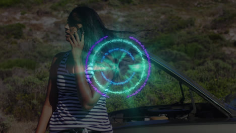 Animation-of-pattern-spinning-with-data-over-biracial-woman-talking-on-phone-by-broken-down-car
