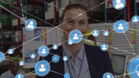 Animation-of-network-of-connections-with-icons-over-caucasian-businesswoman-working-in-warehouse