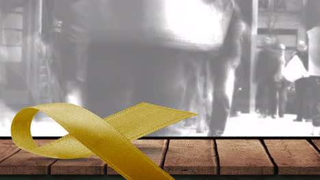 Animation-of-yellow-ribbon-on-wooden-surface-with-grey-cloud