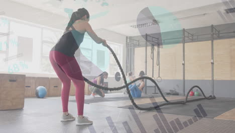Animation-of-data-on-interface-over-caucasian-woman-cross-training-with-battle-ropes-at-gym