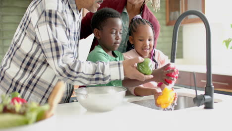 Felices-Abuelos-Y-Nietos-Afroamericanos-Lavando-Verduras-En-La-Cocina,-Cámara-Lenta