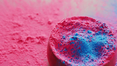 Video-of-pink-and-blue-coloured-powders-and-bowl-with-copy-space-on-black-background