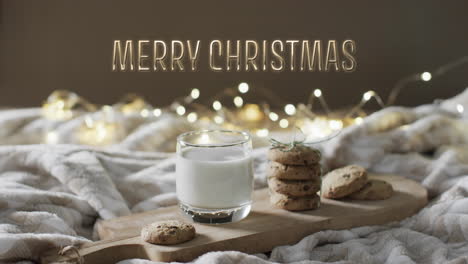Merry-christmas-text-over-christmas-cookies-and-milk-with-string-lights-in-background