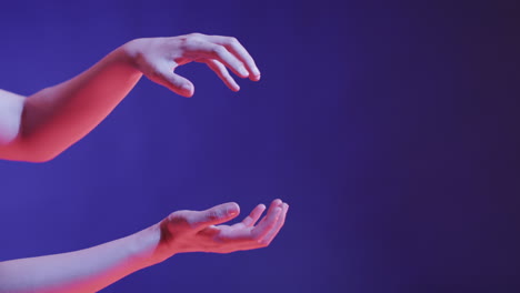 A-Caucasian-person's-hands-are-captured-in-a-graceful-gesture-against-a-blue-background,-with-copy-s